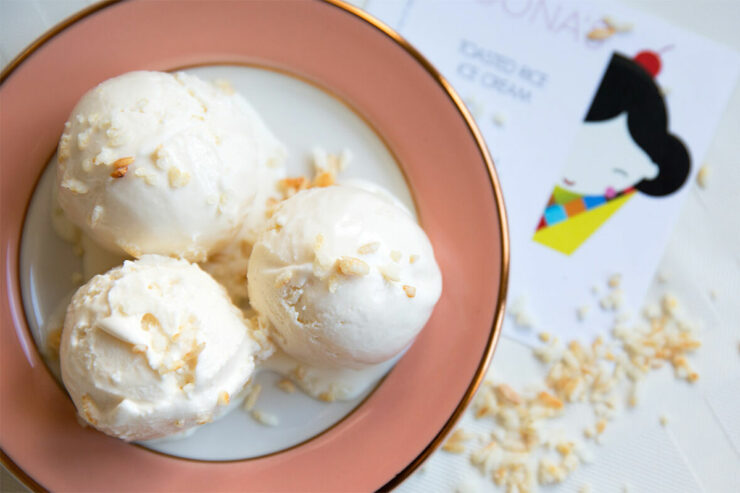 three scoops of ice cream in a white and pink dish