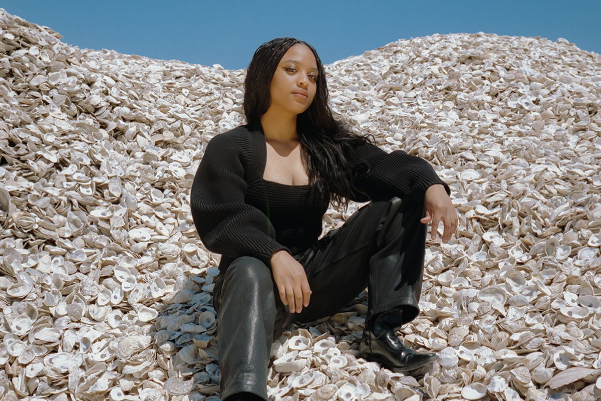 kendal mitchell poses on a large pile of oyster shells